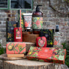 Collection of Bergamot & Ginger themed products on a wooden surface with a brick wall background.