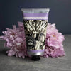 Hand cream tube with floral design and text on a dark background