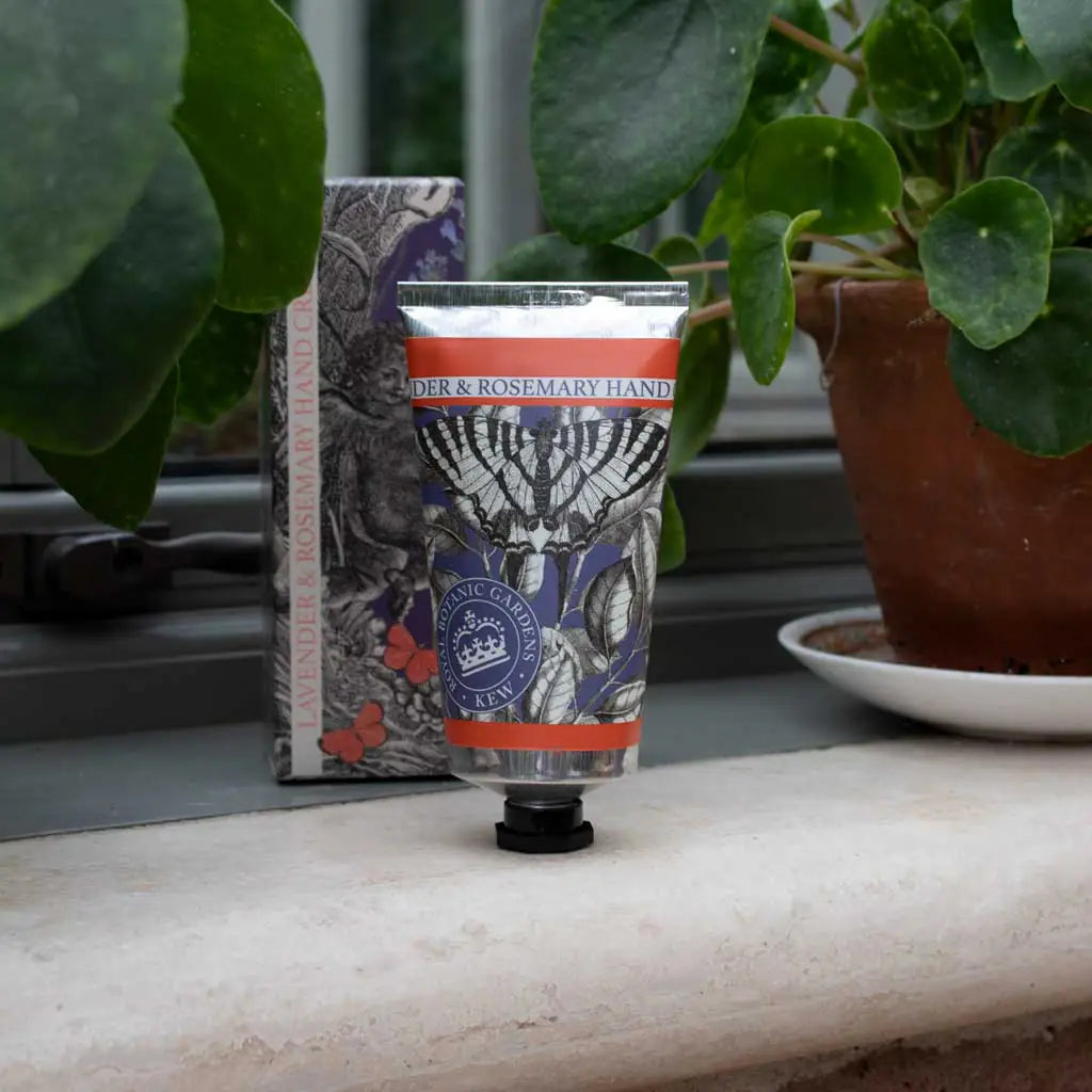 Hand cream with decorative packaging on a surface with plants in the background