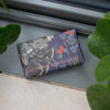 Bar of soap with floral design and text on a metallic surface, surrounded by green leaves.