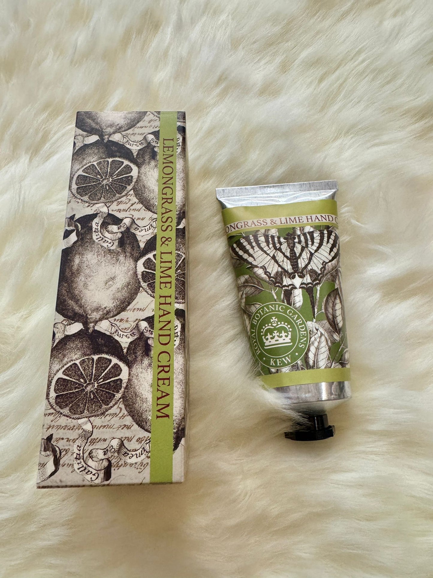 Hand cream with packaging on a textured white surface