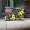 Cosmetic bag with floral and butterfly design on a surface