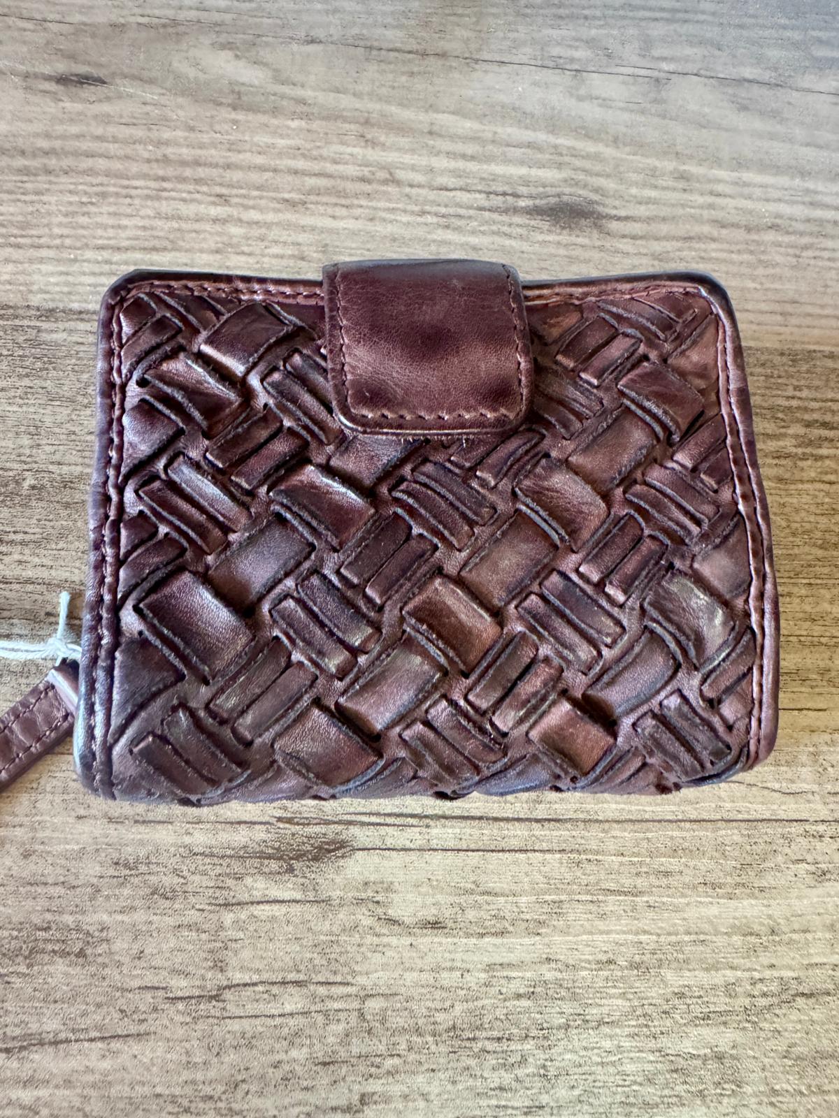 Brown woven leather wallet on a wooden surface