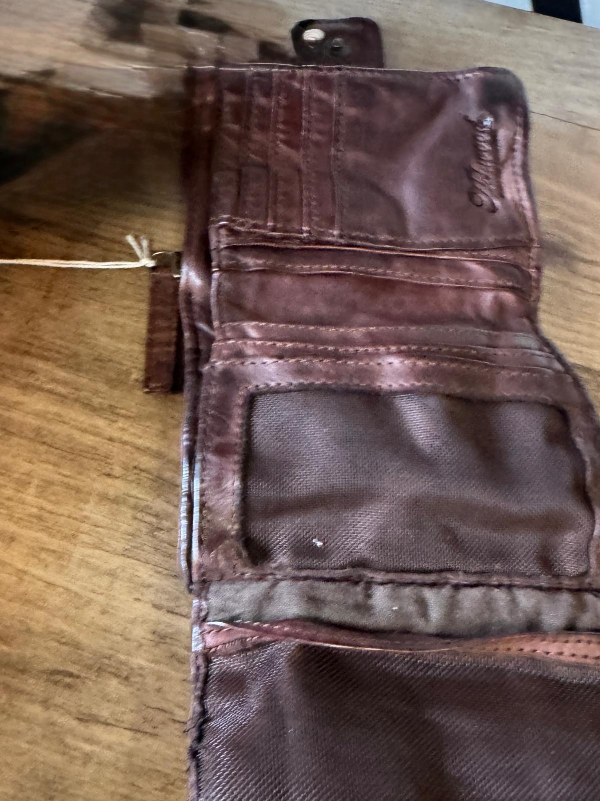 Brown leather wallet on a wooden surface