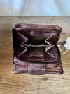 Brown leather wallet on a wooden surface with a white background