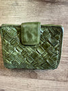 Green woven wallet on a wooden surface