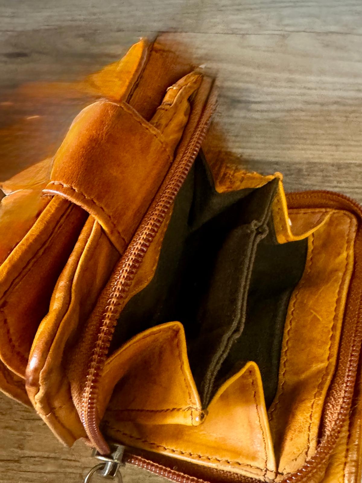 Brown leather wallet with a keychain on a wooden surface