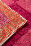 Close-up of a pink and orange textured rug corner