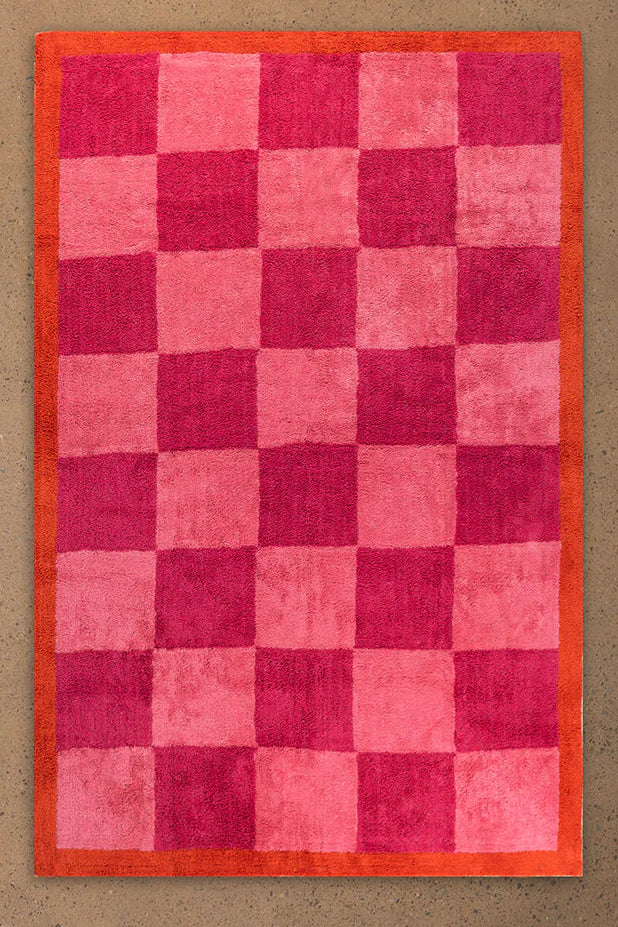 Checkered red and pink rug on a beige floor