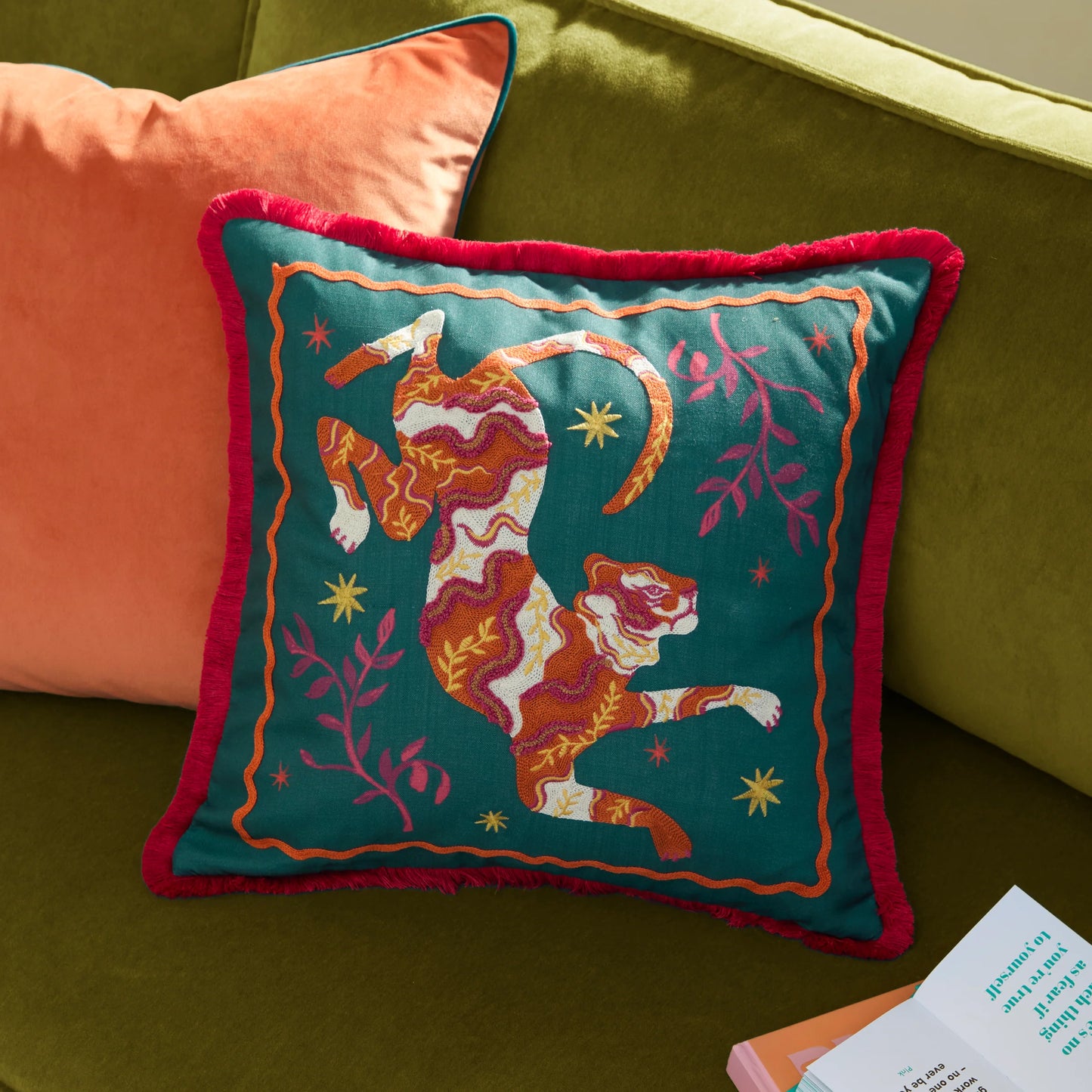 Decorative pillow with a tiger design on a green couch